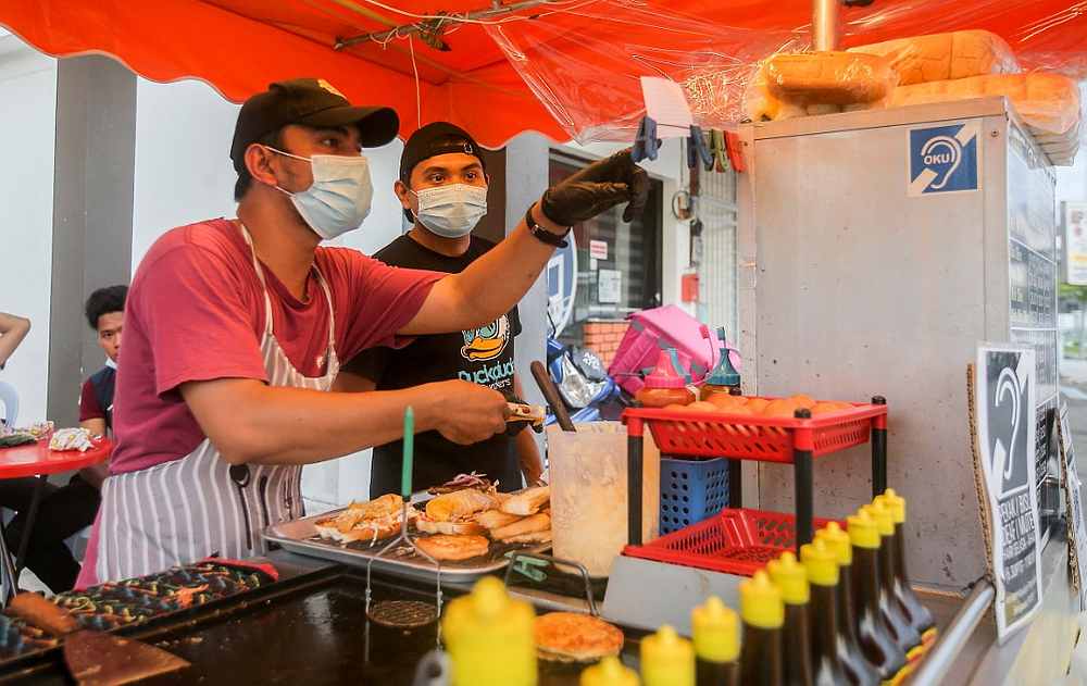 Frie Burger档口有放着听障人士的标志，并要求顾客以书写的方式下单。-Farhan Najib摄-