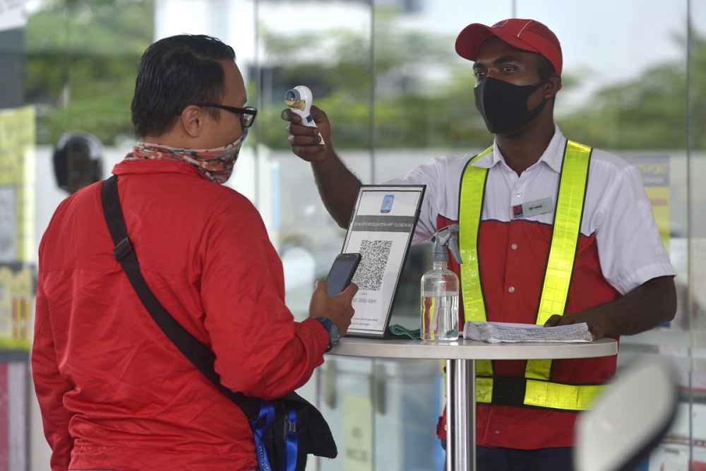 A customer gets his temperature checked before entering the premise of a petrol station in Setia Alam November 10, 2020. u00e2u20acu2022 Picture by Miera Zulyana