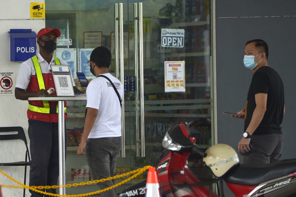 Customers scan the MySejahtera app before entering the premise of a petrol station in Setia Alam November 10, 2020. u00e2u20acu2022 Picture by Miera Zulyana