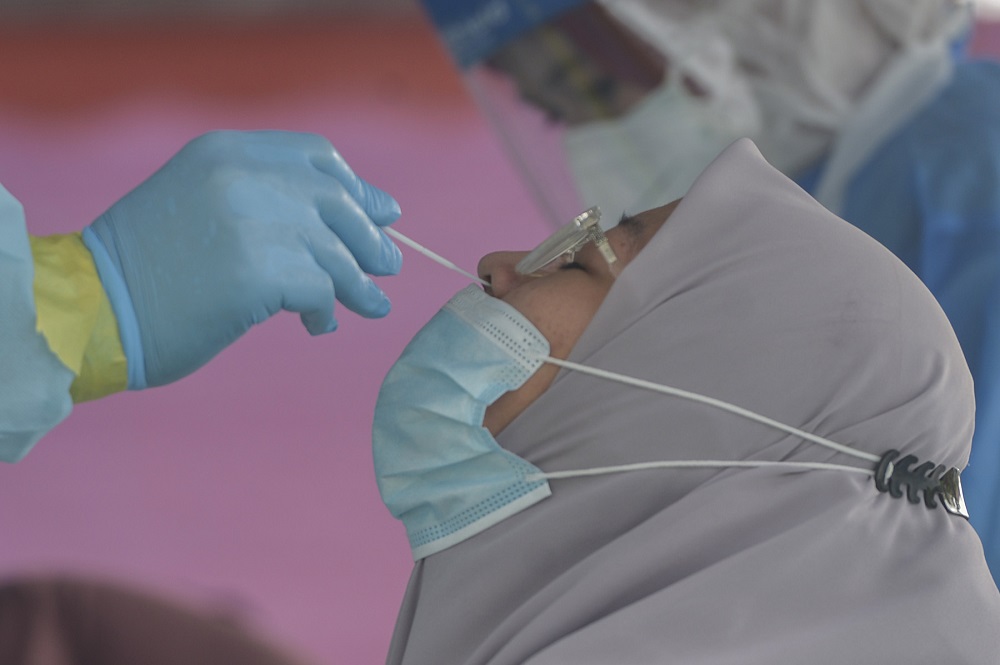 Health workers collect a woman's swab sample to test for Covid-19 at the Dewan Masyarakat Taman Meru 3 in Klang December 2, 2020. u00e2u20acu201d Picture by Miera Zulyana