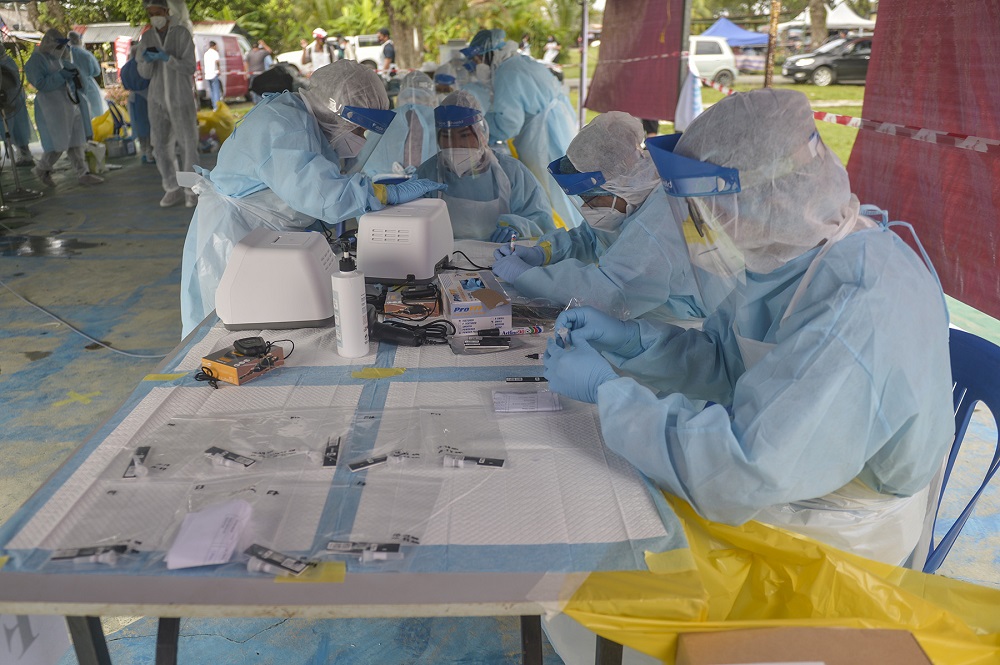 Health workers wearing protective suits are pictured during a community screening operation to test residents for Covid-19 at Taman Meru 3 in Klang December 2, 2020. u00e2u20acu201d Picture by Miera Zulyana