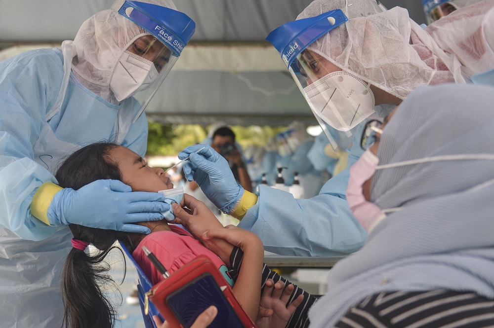 Health workers collect a child's swab sample to test for Covid-19 at Taman Meru 3 in Klang December 2, 2020. u00e2u20acu201d Picture by Miera Zulyana