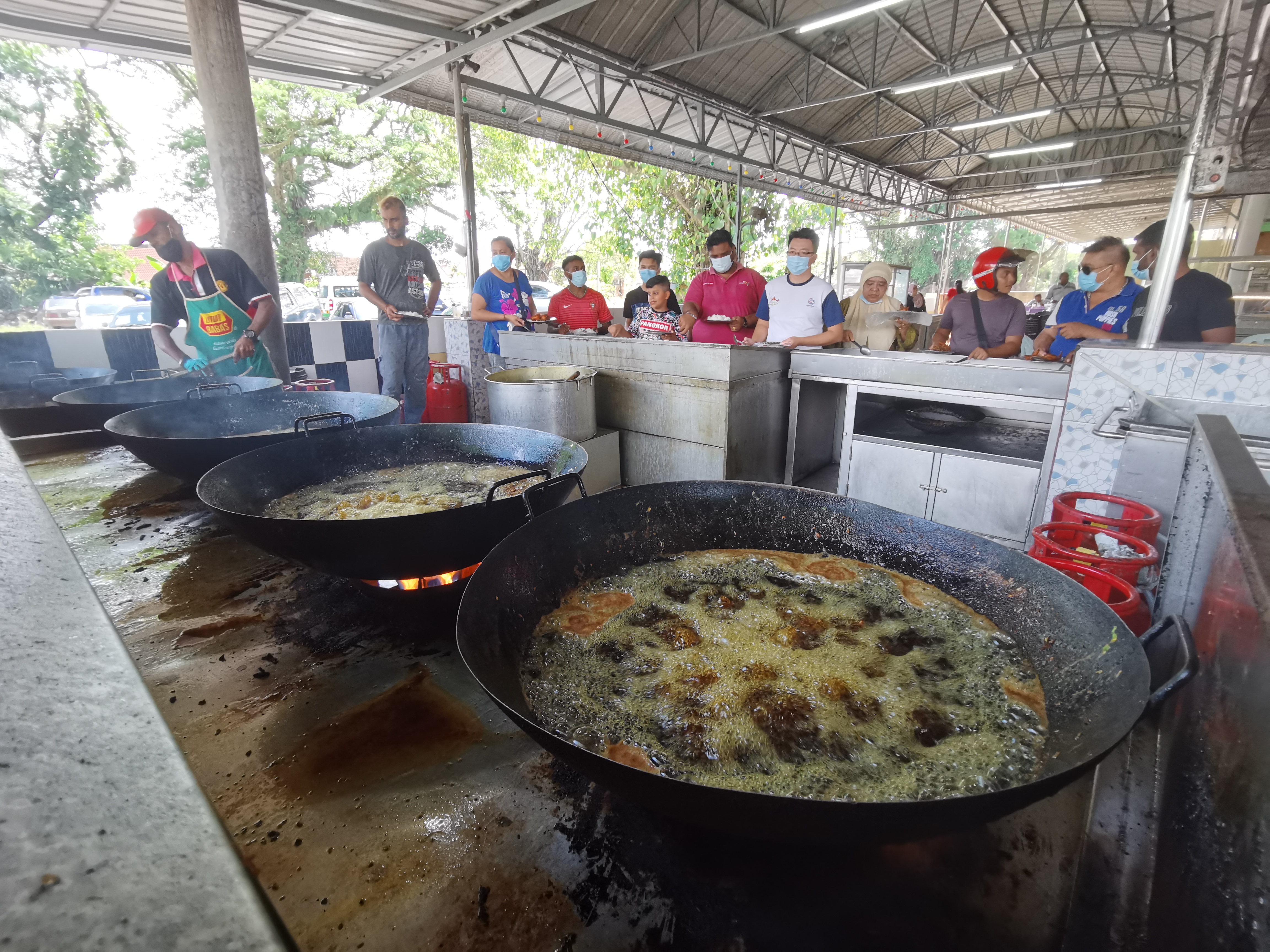 适逢午餐时间，Krishnan Nasi Kandar都会排起长长的人龙，抢购刚出炉的炸鸡。-庄礼文摄-