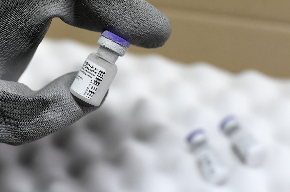 A worker shows a vial of Pfizer-BioNTech Covid-19 vaccine at the arrival of the first shipment in France in the AP-HP central pharmacy on the outskirts of Paris December 26, 2020. u00e2u20acu201d AFP pic