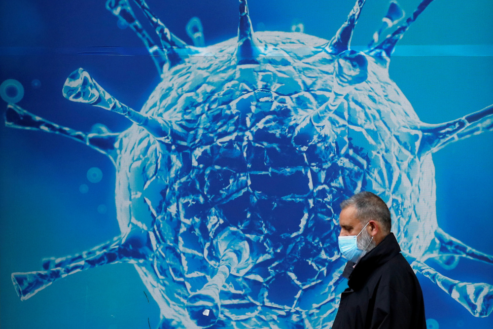 A man wearing a protective face mask walks past an illustration of a virus outside a regional science centre in Oldham, Britain August 3, 2020. u00e2u20acu201d Reuters pic 