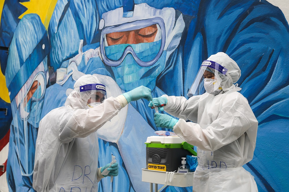 Health workers in protective suit collect swab samples to be tested  for Covid-19 in Shah Alam December 8, 2020. u00e2u20acu2022Picture by Yusof Mat Isa