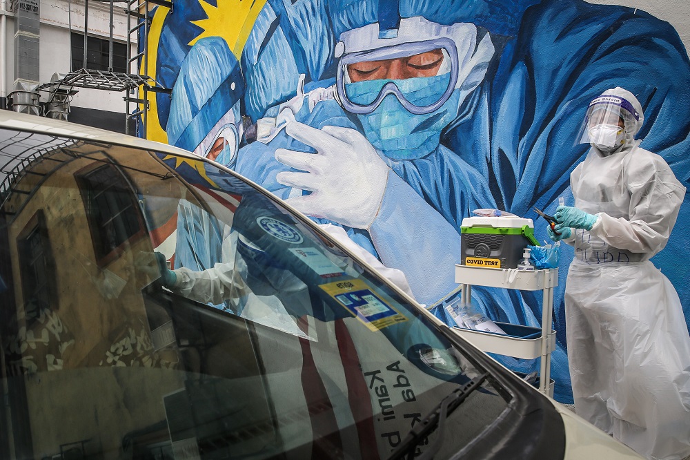 Health workers in protective suit collect swab samples to be tested  for Covid-19 in Shah Alam December 8, 2020. u00e2u20acu2022Picture by Yusof Mat Isa