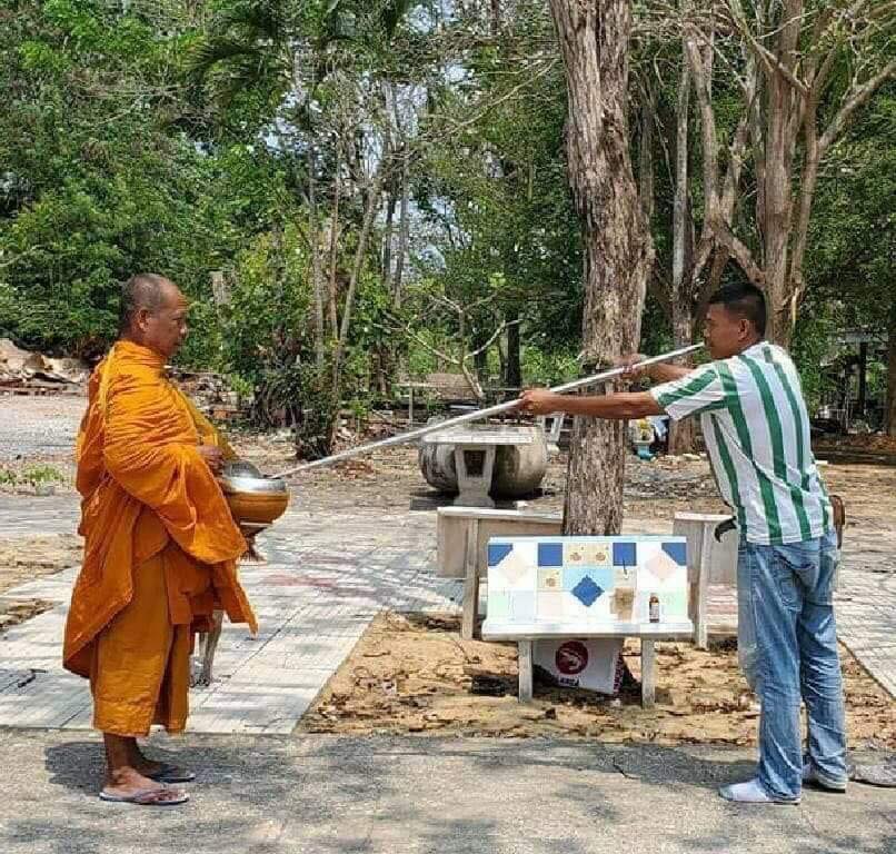 为了保持社交距离,民众使用长竿进行化缘。-图摘自那一年我们在曼谷-曼谷帮脸书-