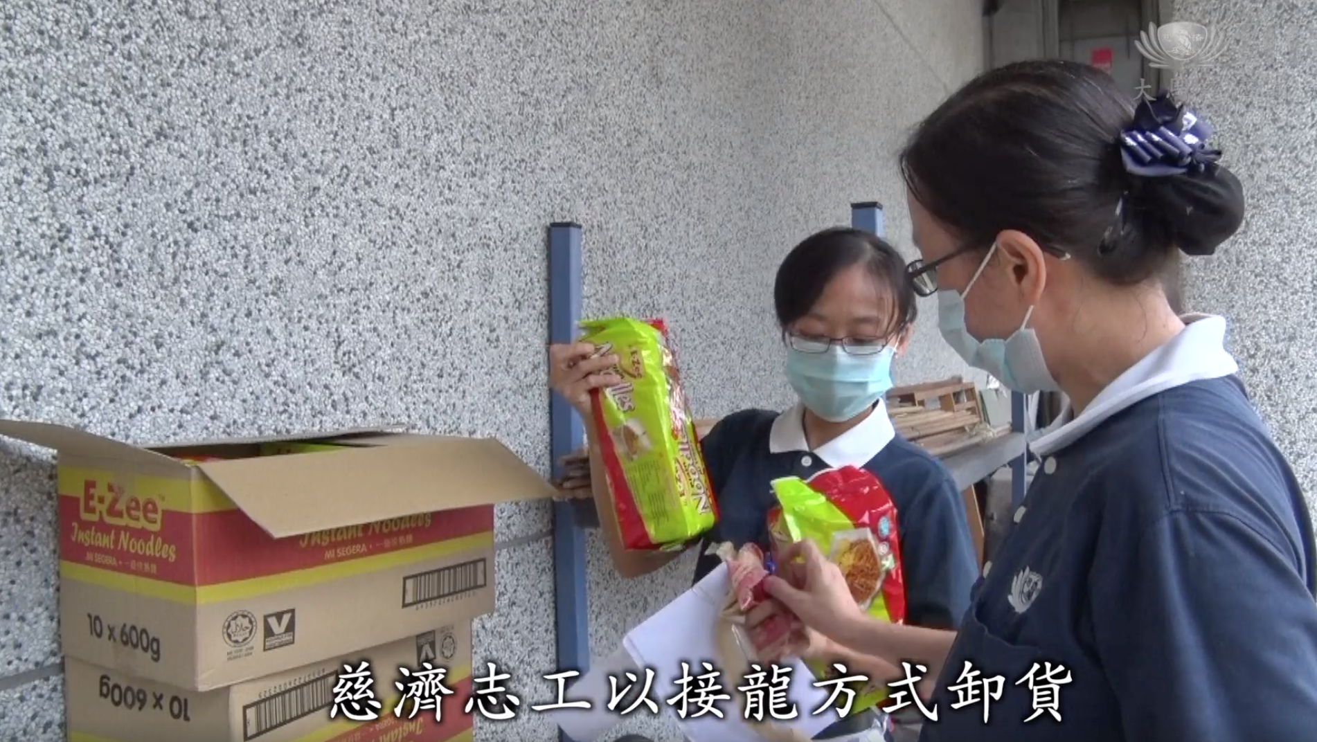 慈济志工以接龙方式卸货将发放给难民粮食分类装箱。-截图自马来西亚慈济基金会脸书-