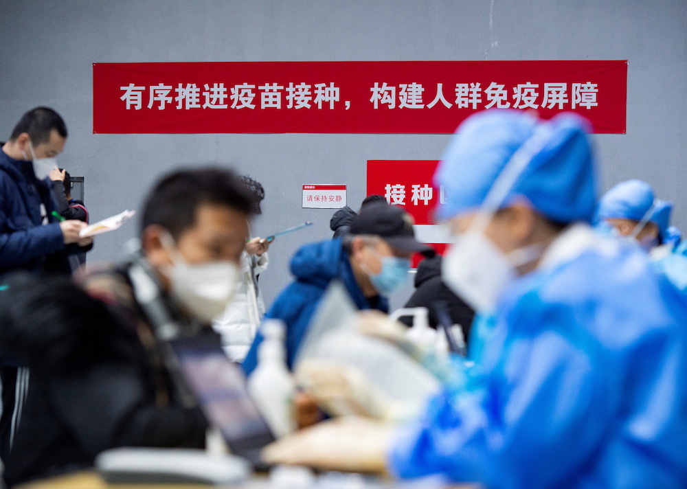 People submit forms to receive the Covid-19 vaccine at a makeshift vaccination site in Beijing's Chaoyang district, China January 3, 2021. u00e2u20acu201d cnsphoto via Reuters 