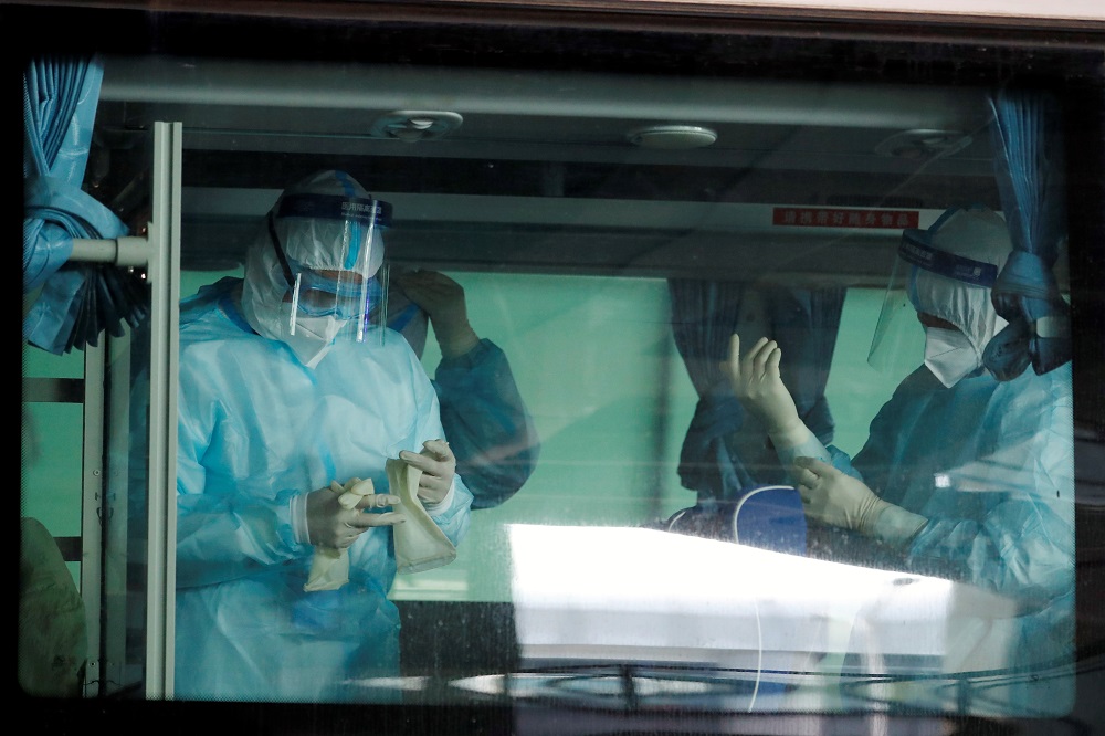 Medical workers get ready inside a bus before the expected arrival of a WHO team tasked with investigating the origins of the coronavirus disease pandemic, at Wuhan Tianhe International Airport in Wuhan, Hubei province, China January 14, 2021. u00e2u20acu201d Reuters