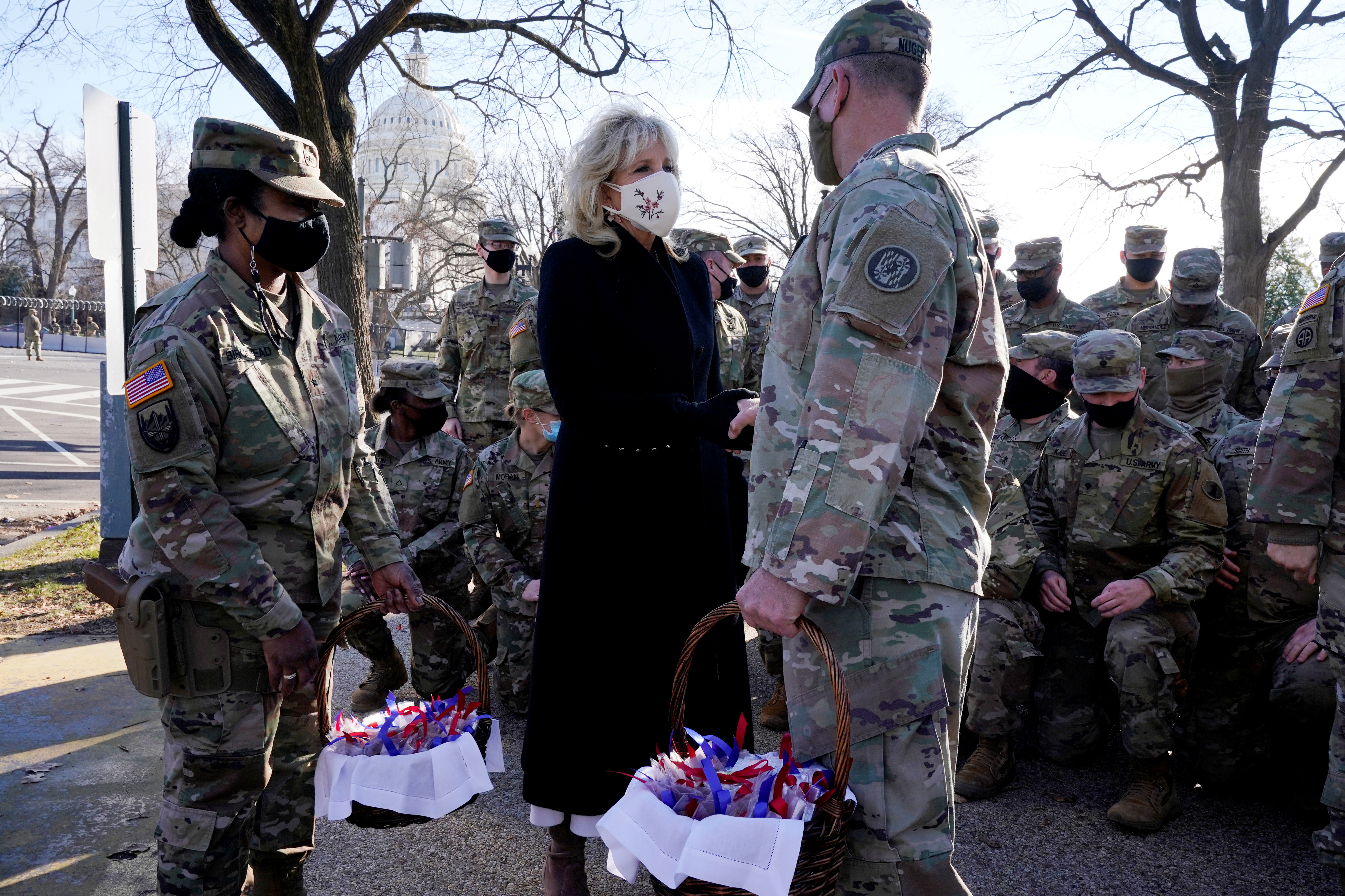 美国第一夫人吉尔（黑衣）周五向当值士兵送上曲奇饼。-路透社-