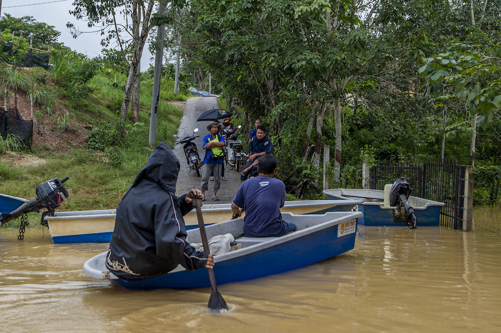 Lebak Seberang villagers ride a boat through floodwaters following a heavy monsoon downpour in Temerloh, Pahang on January 9, 2021 u00e2u20acu201d Picture by Shafwan Zaidonn