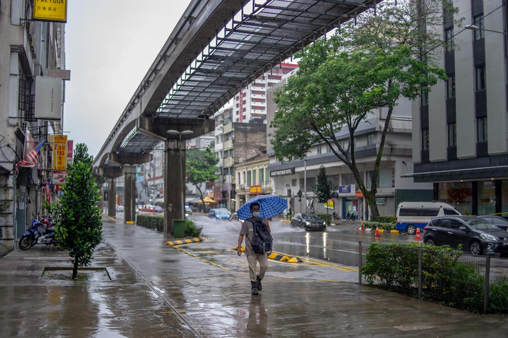 A man walking with an umbrella in the deserted city of Kuala Lumpur on January 17, 2021. u00e2u20acu201d Picture by Shafwan Zaidon