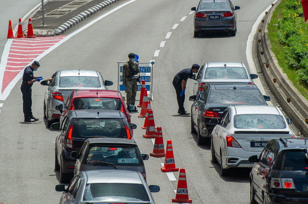 Police officers conducting checks at a roadblock in Jalan Kuching, Kuala Lumpur January 31, 2021. u00e2u20acu201d Picture by Shafwan Zaidon 