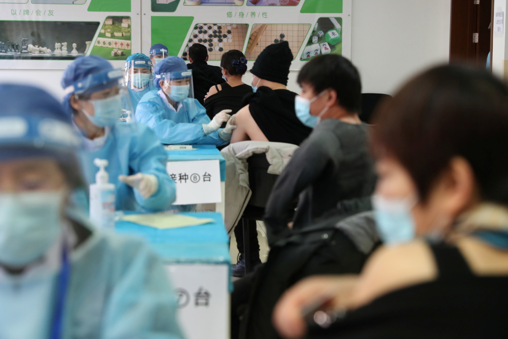 Medical workers in protective suits administer the vaccine against the coronavirus disease at a makeshift vaccination site in Beijingu00e2u20acu2122s Haidian district, China January 8, 2021. u00e2u20acu201d cnsphoto handout pic via Reuters 