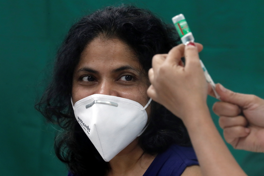 A healthcare worker looks on as a nurse prepares a dose of the AstraZenecau00e2u20acu2122s COVISHIELD vaccine, during the coronavirus disease vaccination campaign, at a medical centre in Mumbai, India, January 16, 2021. u00e2u20acu201d Reuters pic