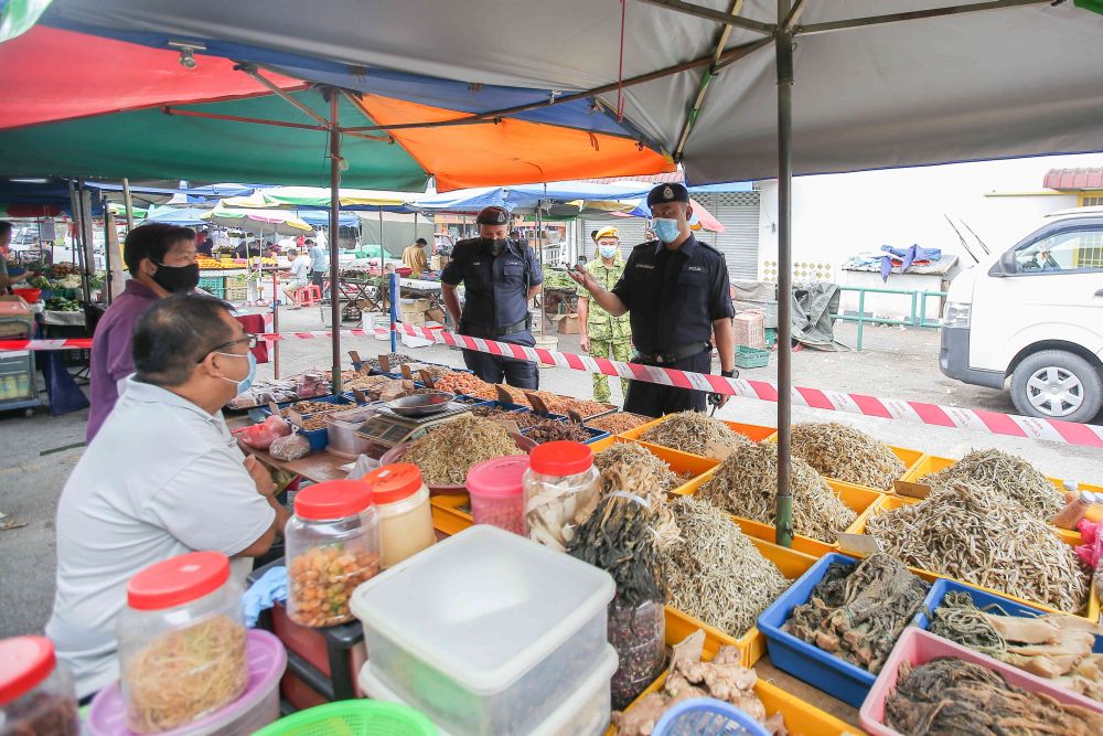 nPolice personnel conduct checks on Pasar Gunung Besar amid the movement control order in Ipoh January 22, 2021. u00e2u20acu201d Picture by Farhan Najibn