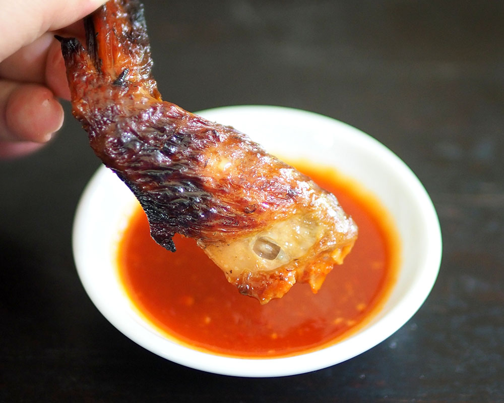 若沾一点辣椒酱，烧鸡翅的味道会更美味。- Lee Khang Yi摄-