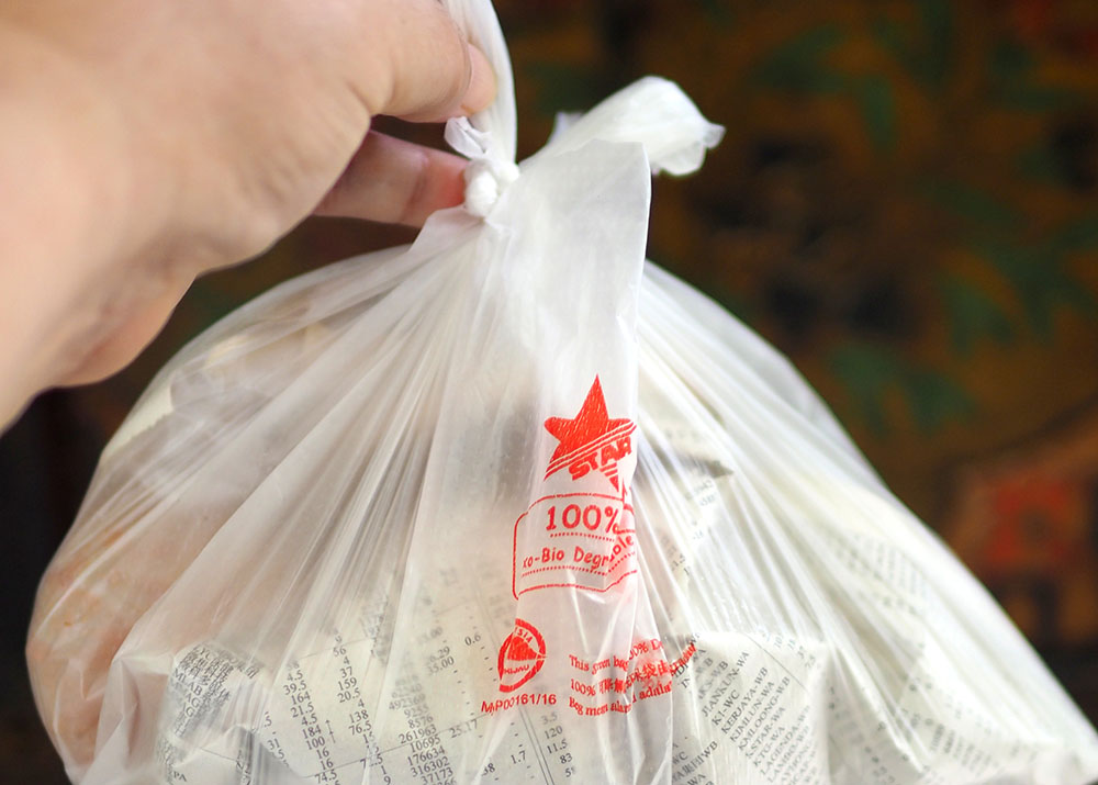 他们会用报纸将烧鸡翅包起来，然后再用袋子装。- Lee Khang Yi摄-