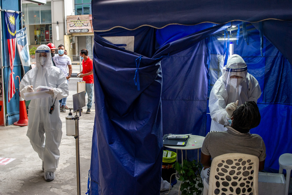 A health worker uses a swab to collect a sample for Covid-19 testing from a man in Jalan Pudu, Kuala Lumpur, January 18, 2021. u00e2u20acu201d Picture by Shafwan Zaidon