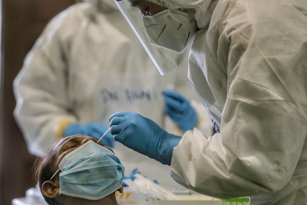 A healthcare worker collects swab samples to test for Covid-19 at Dewan Desa Temuan in Kota Damansara January 29, 2021. u00e2u20acu201d Picture by Ahmad Zamzahurinn