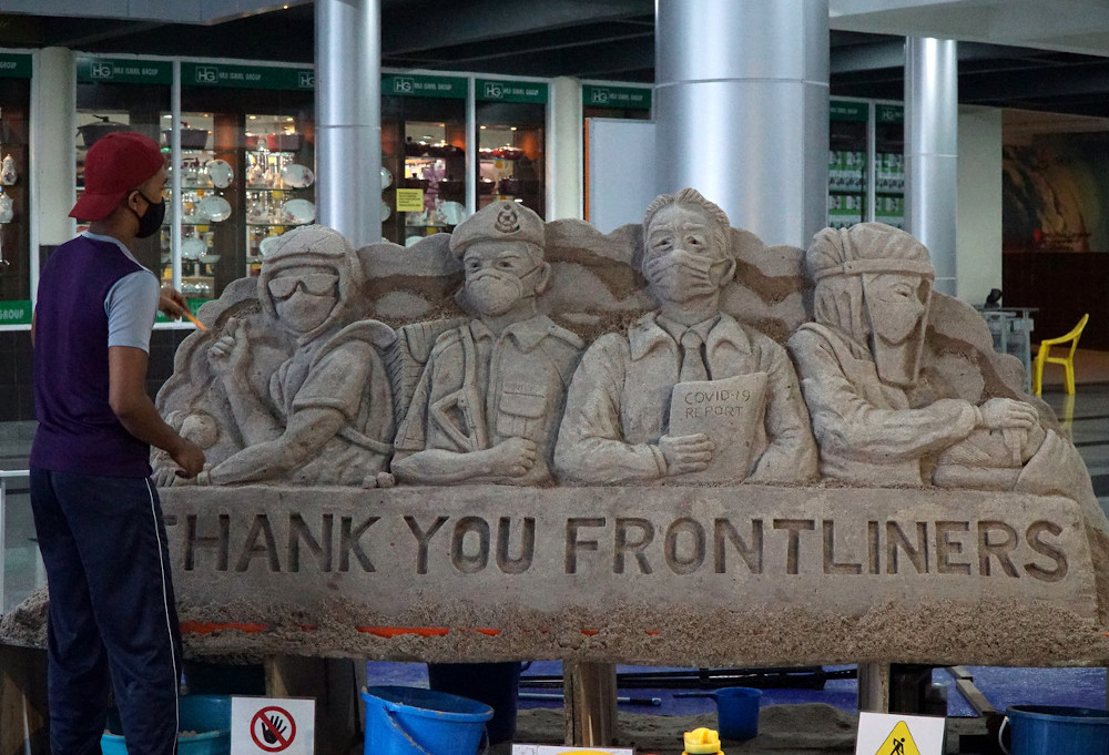 Mohammad Ikhwan Ibrahim puts the finishing touches to his sand sculpture honouring Malaysiau00e2u20acu2122s frontliners in Langkawi, January 5, 2021. u00e2u20acu201d Bernama pic 