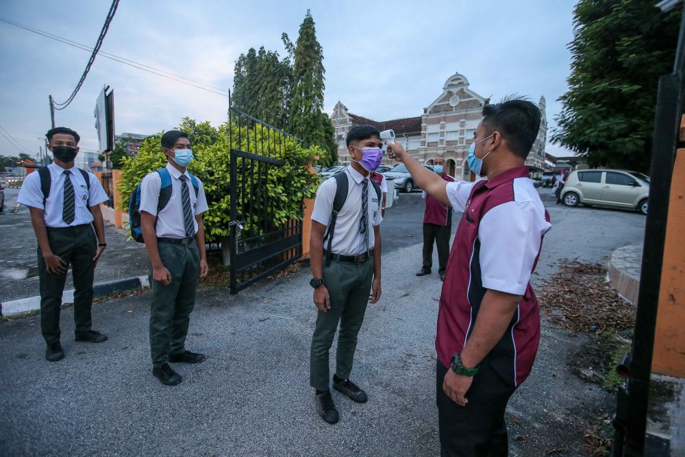 Students have their temperature taken at Sekolah Menengah Kebangsaan Methodist (ACS), Ipoh  January 20, 2021. u00e2u20acu201d Picture by Farhan Najib