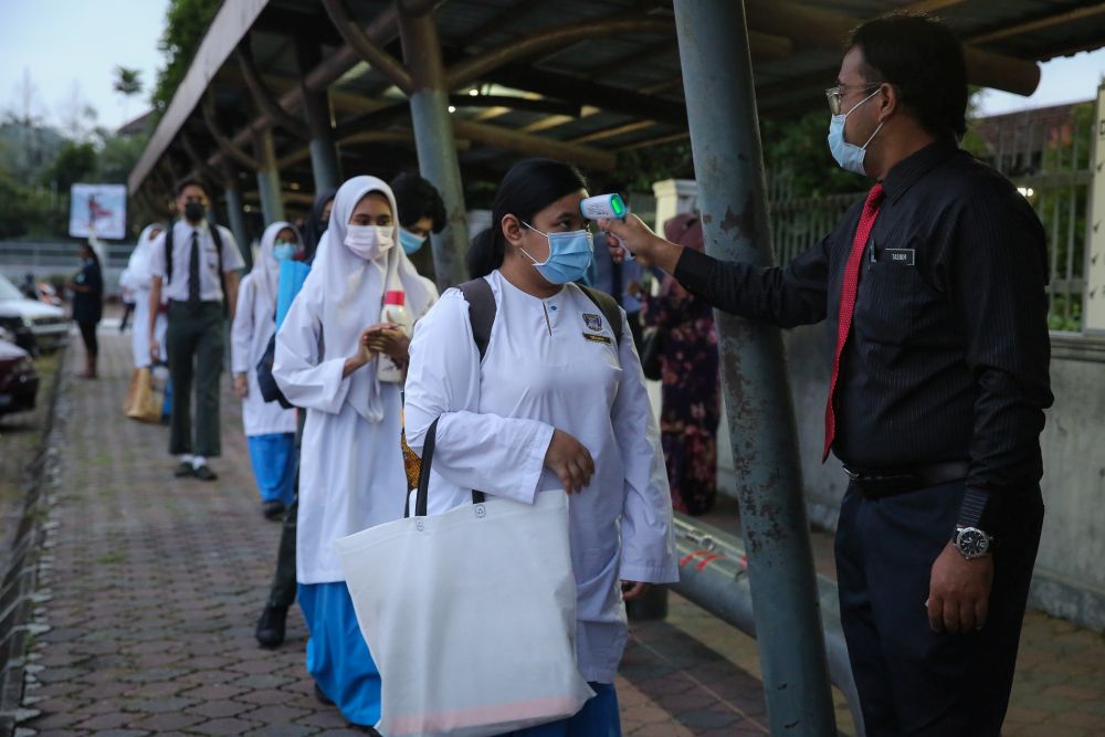 Students wait to have their temperature taken at Sekolah Menengah Kebangsaan Bukit Jelutong in Shah Alam January 20, 2021. u00e2u20acu201d Picture by Yusof Mat Isa