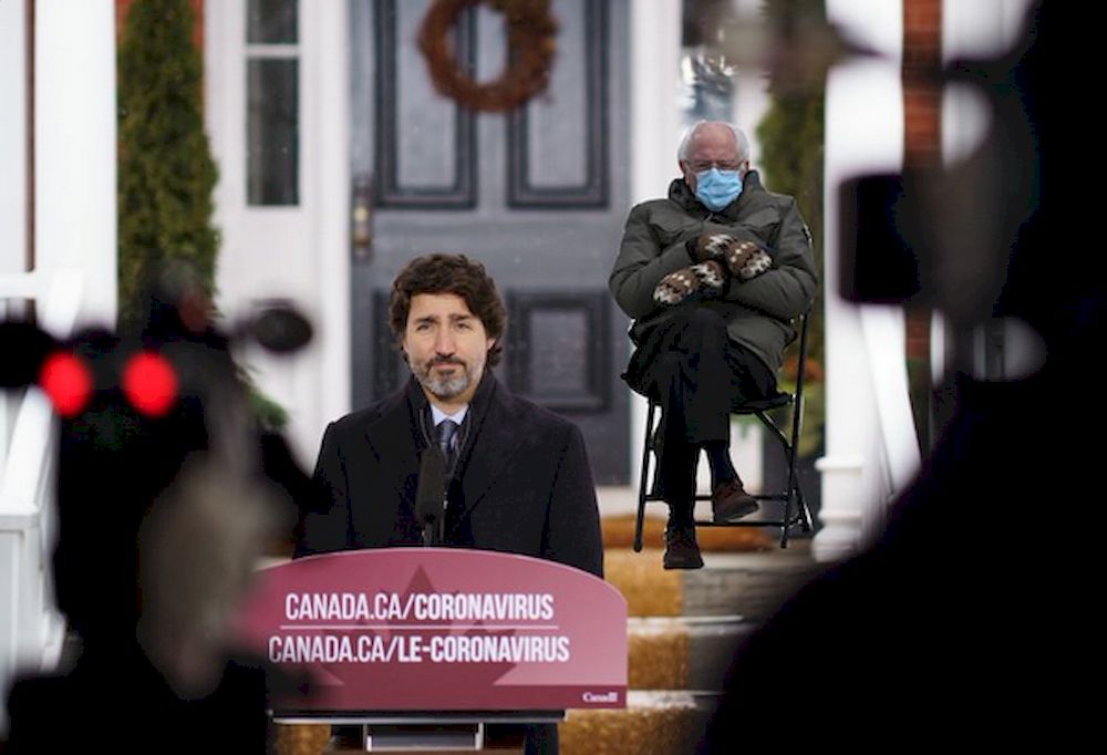 Canadian Prime Minister Justin Trudeau posted a photo of himself giving a press conference from his lawn with the image of a seated, mitten-clad Bernie Sanders superimposed in the background. u00e2u20acu201d Picture via Twitter@JustinTrudeau