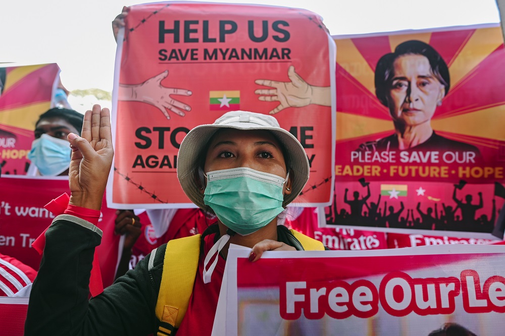 A demonstrator flashes a three-finger salute while holding a sign to protest against the military coup and demand for the release of elected leader Aung San Suu Kyi, in Yangon February 12, 2021. u00e2u20acu201d Reuters pic