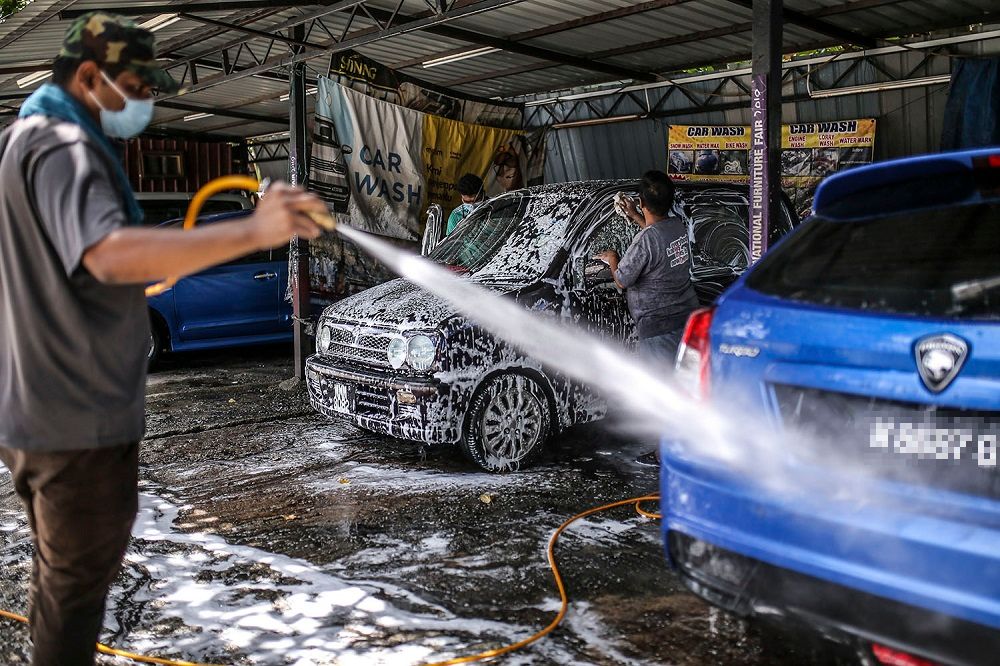 Staff at a car wash centre are seen hard at work in Kuala Lumpur February 6, 2021. u00e2u20acu201d Picture by Hari Anggara