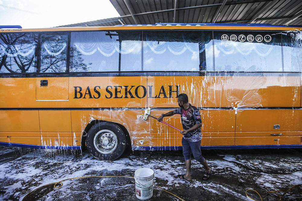 Car wash workers are seen cleaning school buses in preparation for schools reopening on Monday, Petaling Jaya February 27, 2020. u00e2u20acu2022 Picture by Hari Anggara.nnn