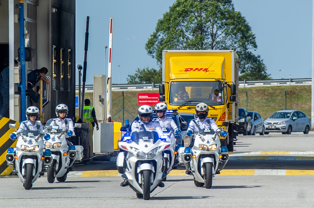 A convoy of DHL Express vehicles carry the first batch of Pfizer-BioNTech's Covid-19 vaccine with police escort from Cargo Village in KLIA, February 21, 2021. u00e2u20acu201d Picture by Shafwan Zaidon