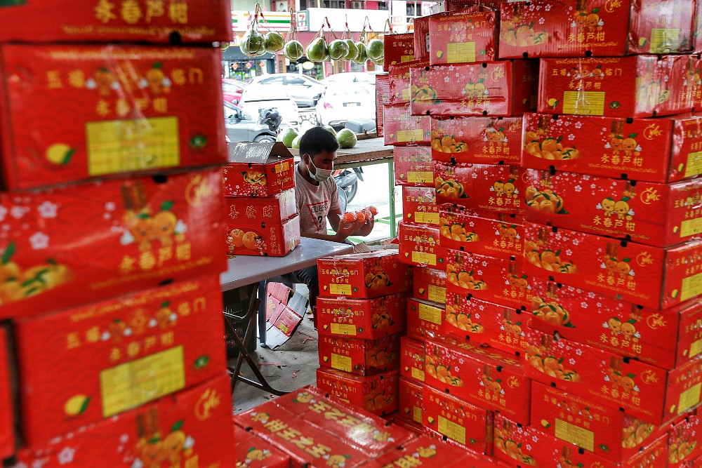 A fruit seller sorting out boxes of mandarin oranges for his customers ahead of Chinese New Year celebrations, February 2, 2021. u00e2u20acu201d Picture by Ahmad Zamzahuri
