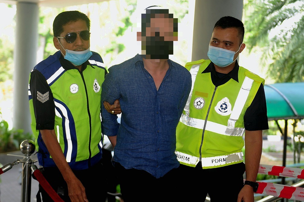 The 34-year-old founder of the u00e2u20acu02dcSugarbooku00e2u20acu2122 app (centre) is led to the High Court in Kuala Lumpur February 18, 2021. u00e2u20acu201d Bernama pic