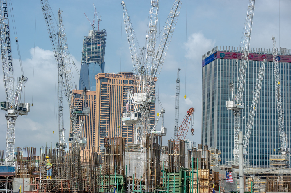 Construction workers walking across a platform at a building site in Kuala Lumpur February 14, 2021. u00e2u20acu201d Picture by Shafwan Zaidon