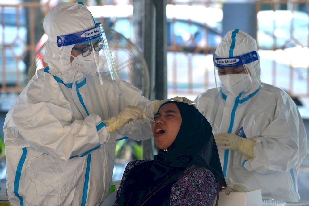 A health worker administering Covid-19 test on a resident in Puchong, February 28,2021. u00e2u20acu201d Picture by Miera Zulyana