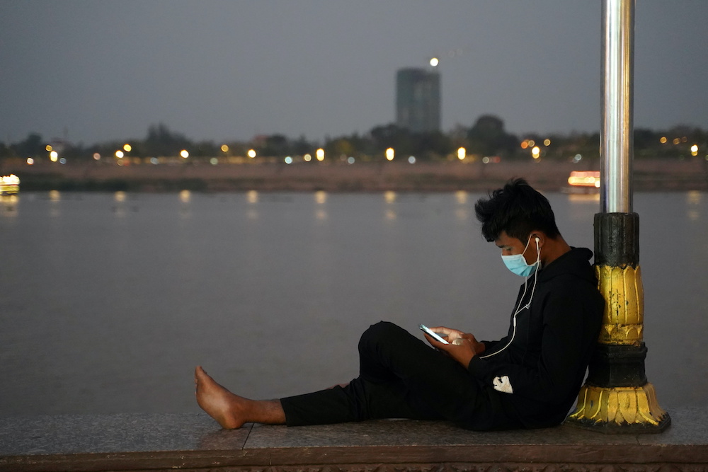 A man uses his mobile phone on the Tonle Sap riverside amid the coronavirus pandemic in Phnom Penh, Cambodia, February 18, 2021. u00e2u20acu201d Reuters picnn