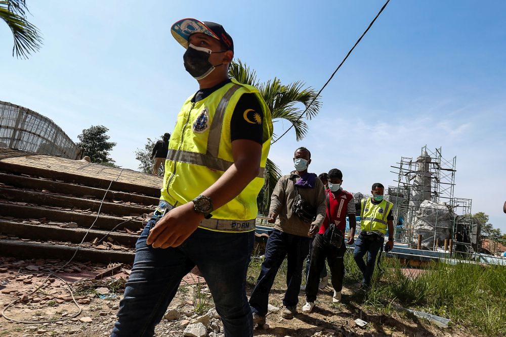 Police personnel round up foreign workers found flouting Covid-19 SOP and without proper documentation at a construction site in Bertam February 8, 2021. u00e2u20acu201d Picture by Sayuti Zainudinnn