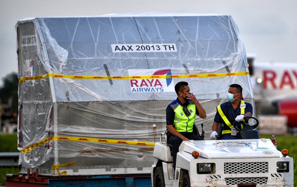 Staff of Raya Airways with the first batch of the Pfizer-BioNTech vaccine for Sarawak at the Kuching International Airport, February 24, 2021. u00e2u20acu201d Bernama pic    