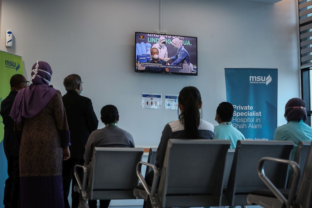 Staff at the MSU Medical Centre watch a live broadcast of Prime Minister Tan Sri Muhyiddin Yassin receiving his Covid-19 jab in Shah Alam February 24, 2021. u00e2u20acu2022 Picture by Yusof Mat Isa