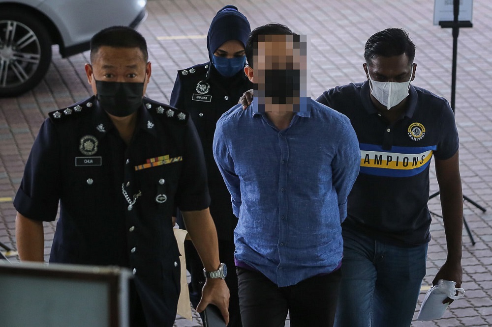 Controversial dating site Sugarbooku00e2u20acu2122s founder is escorted by policemen as he arrives at the High Court complex in Shah Alam February 19, 2021. u00e2u20acu2022 Picture by Yusof Mat Isa