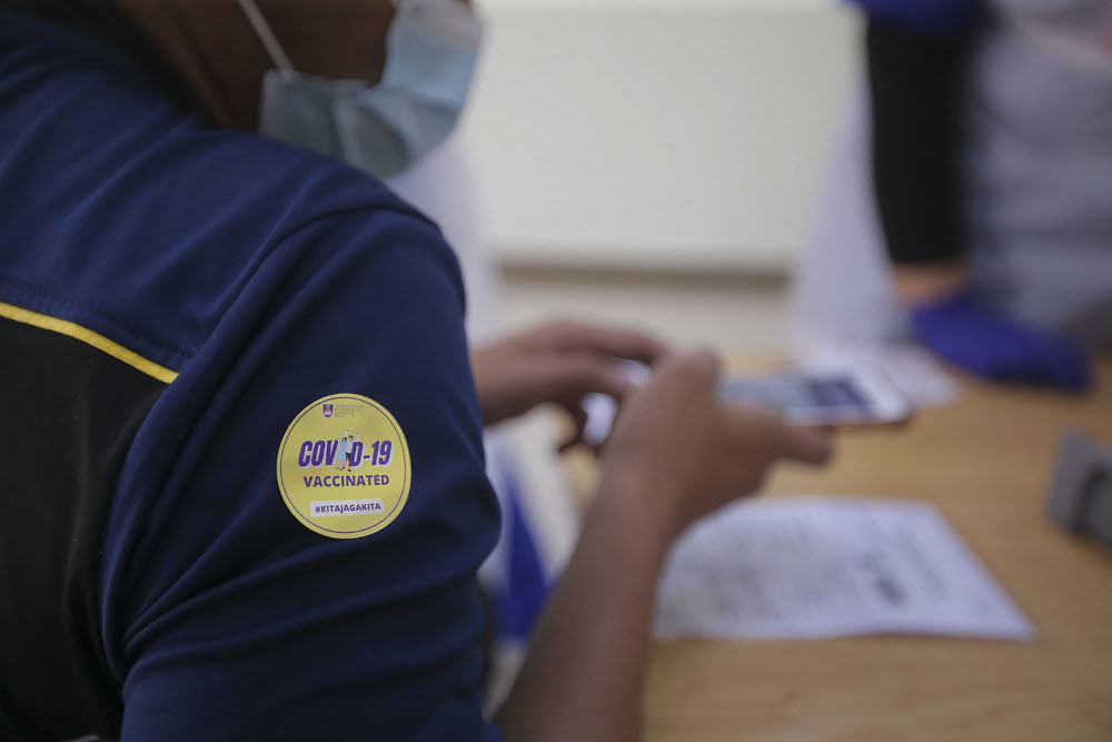 A healthcare worker administers a dose of the Pfizer-BioNTech Covid-19 vaccine to a frontliner at the UiTM Private Specialist Centre in Sungai Buloh March 2, 2021. u00e2u20acu2022 Picture by Hari Anggara