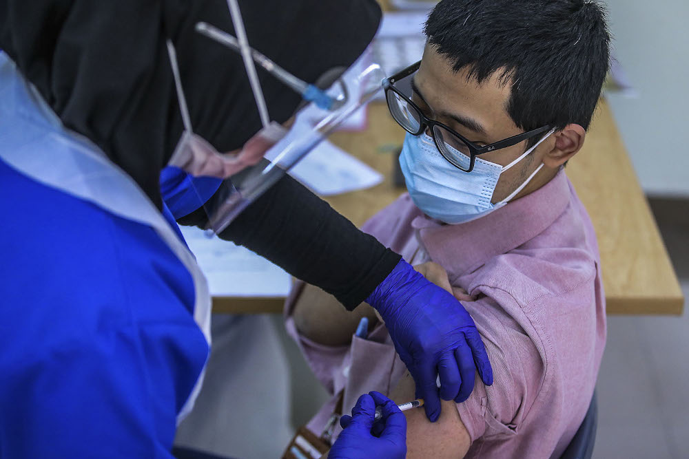 A healthcare worker administers a dose of the Pfizer-BioNTech Covid-19 vaccine to a frontliner at the UiTM Private Specialist Centre in Sungai Buloh March 2, 2021. u00e2u20acu2022 Picture by Hari Anggara