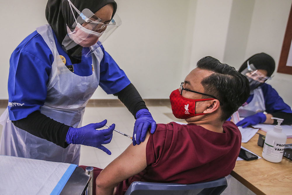 A healthcare worker administers a dose of the Pfizer-BioNTech Covid-19 vaccine to a frontliner at the UiTM Private Specialist Centre in Sungai Buloh March 2, 2021. u00e2u20acu2022 Picture by Hari Anggara