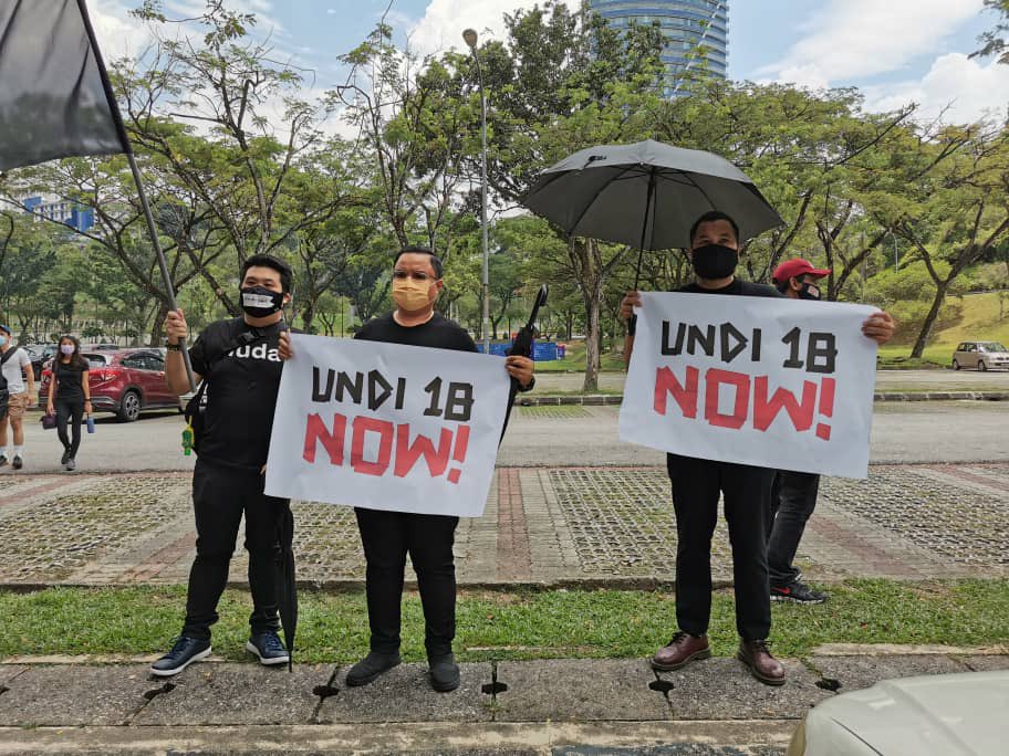 People hold placards as they protest against the Election Commission in Kuala Lumpur March 27, 2021. u00e2u20acu201d Picture via Twitter/partimuda