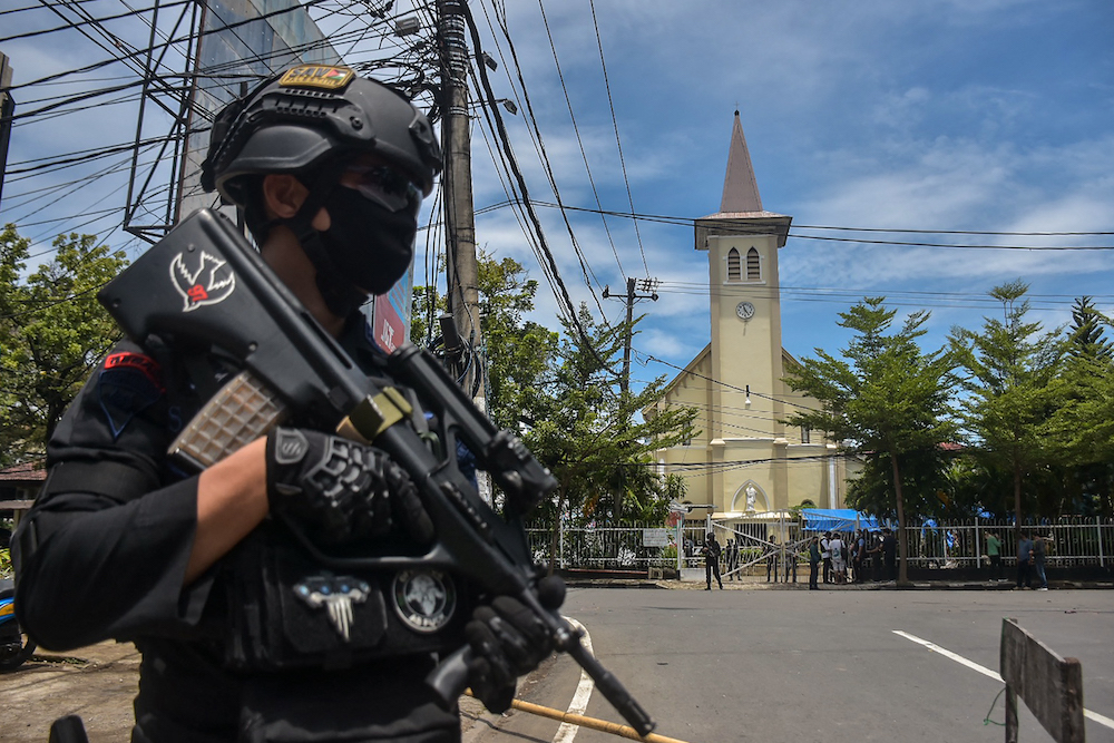 An Indonesian policeman stands guard outside a church after an explosion in Makassar March 28, 2021. u00e2u20acu201d AFP pic