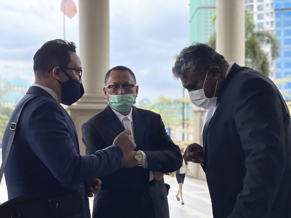 Datuk Mohd Puad Zarkashi (centre) speaks to his lawyers at the Kuala Lumpur High Court March 12, 2021. u00e2u20acu201d Picture by Emmanuel Santa Maria Chin