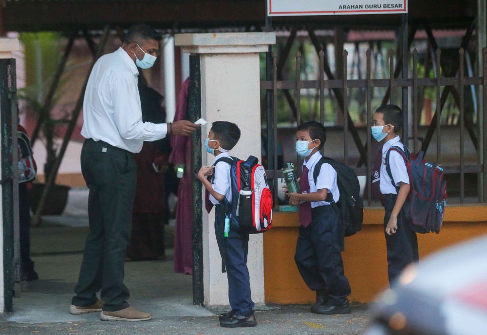 A student has his temperature checked at Sekolah Kebangsaan Cator Avenue, Ipoh as schools reopen March 1, 2021. u00e2u20acu201d Picture by Farhan Najib